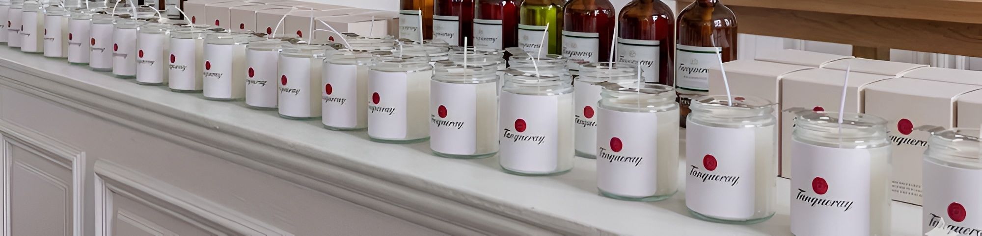 Hand-poured branded candles lined up in the Monde Des Parfum workshop